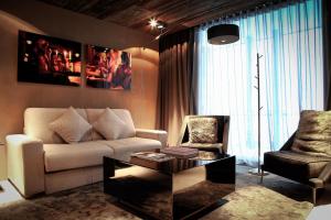 Sala de estar con sofá, silla y mesa de centro en Hotel Zhero – Ischgl/Kappl en Kappl