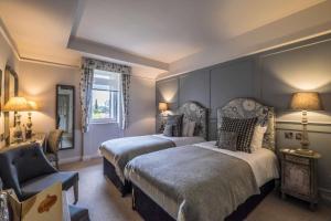a bedroom with a large bed and a large window at Coach & Horses Hotel in London