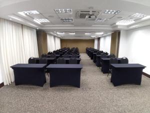 une grande chambre avec des chaises et des tables. dans l'établissement Kayrós Business Hotel, à Jaraguá do Sul