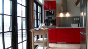 a kitchen with red cabinets and a wooden table at Romantic-HuntingLodge-en-Provence**** in Saint-Pierre