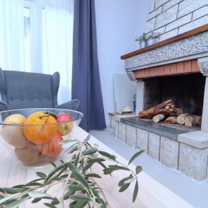 a bowl of fruit on a table in front of a fireplace at Holiday Home Rosemary in Klek
