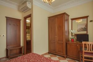 a bedroom with a bed and a desk and a cabinet at Hotel RomAntica in Rome