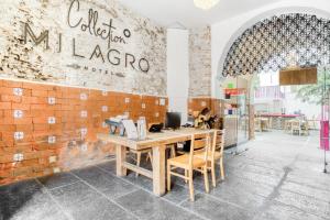 a restaurant with a wooden table and a brick wall at Milagro Hotel in Puebla