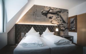 a bed with white pillows and a painting on the wall at Landhaus Hechtsberg in Hausach +16 photos