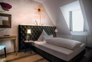 ハウザッハにあるLandhaus Hechtsbergのベッドルーム1室(壁に花を飾ったベッド1台付)