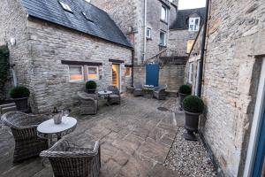 a patio with a table and chairs in a courtyard at The Bell & Stuart House in Stow on the Wold
