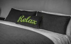 a bed with two pillows with the word relax on it at Pullman House in Darlington