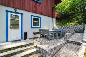 a patio with two benches next to a house at Apartamentai Geliu Vila in Nida