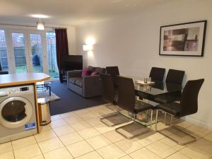 a living room with a table and chairs and a kitchen at Comfortable and Welcoming Beatrix House by Cliftonvalley Apartments in Bristol