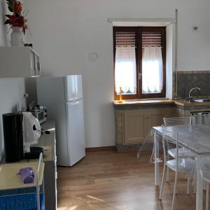 Il comprend une cuisine équipée d'une table et d'un réfrigérateur blanc. dans l'établissement casavacanze olmata, à Montevirginio