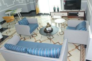 a living room with a couch and chairs and a television at IMD Residence in Douala +19 photos