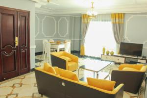 a living room with yellow chairs and a table at IMD Residence in Douala