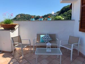 a patio with chairs and a table and a window at "CASA SUNSET" in Ischia