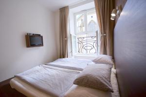 ein kleines Bett in einem Zimmer mit Fenster in der Unterkunft Jacob Brno in Brünn