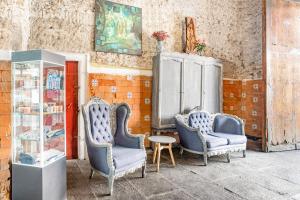 two chairs and a table in a room at Hotel Milagro, Puebla Centro in Puebla