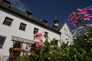 a white house with flowers in front of it at Seminar- und Gästehaus im Kloster Bezau in Bezau