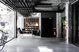 an industrial room with a black door and some chairs at SOF Hotel in Taichung