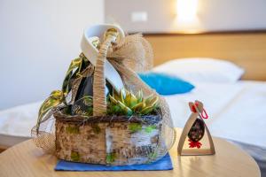 una cesta con una planta en ella sentada en una mesa en Hotel Bela Krajina en Metlika