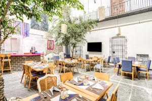 a restaurant with wooden tables and chairs and a tv at Milagro Hotel in Puebla