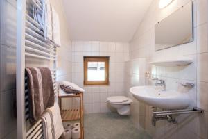 ein weißes Bad mit einem Waschbecken und einem WC in der Unterkunft Bauernhof im Zillertal, der Badererhof in Stumm