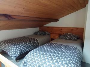 two beds in a room with wooden ceilings at Logement 88 2-4 Personnes 500 m plage classé 2 étoiles in Dolus d'Oléron