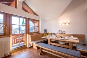 una sala da pranzo con tavolo, panche e finestre di Badererhof Christine Wechselberger a Stumm