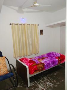 Bett in einem Zimmer mit Fenster in der Unterkunft Mayurapriya Inn in Chennai