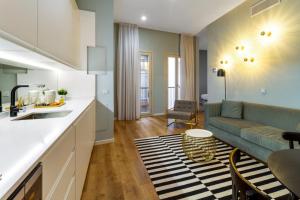 a kitchen and living room with a couch and a table at Apartamentos Casapalma Centro Histórico in Málaga