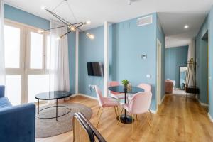 a living room with a table and pink chairs at Apartamentos Casapalma Centro Histórico in Málaga