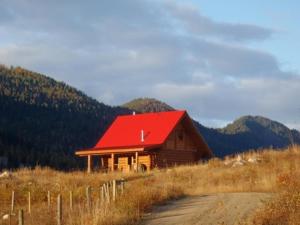 a barn with a red roof in a field at Bear Valley Highlands in Lumby