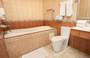 La salle de bains est pourvue de toilettes, d'une baignoire et d'un lavabo. dans l'établissement Hotel Puntarenas Beach, à Puntarenas