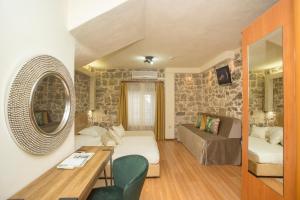 uma pequena sala de estar com uma parede de pedra em Authentic Luxury Rooms em Split