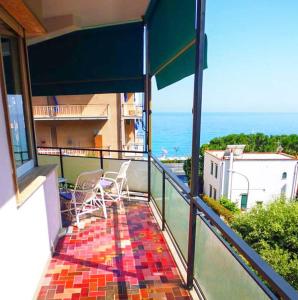 d'un balcon avec des chaises et une vue sur l'océan. dans l'établissement Ampio alloggio molto confortevole, 7 posti letto, à Spotorno