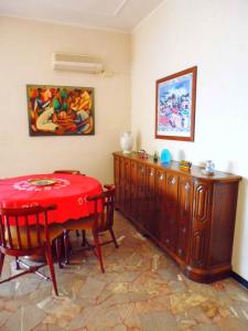 une salle à manger avec une table et des chaises rouges dans l'établissement Ampio alloggio molto confortevole, 7 posti letto, à Spotorno