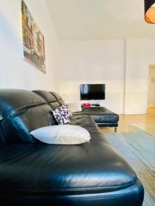 a black leather couch with a pillow on it at Rock in Share - Le Saint-Pierre in Metz