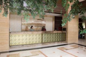 two women standing at a counter in a lobby at DE GREEN INN Kebon Jeruk in Jakarta
