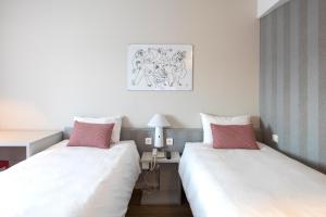 um quarto com duas camas e uma mesa e uma foto em Ibis Valencia Alfafar em Alfafar