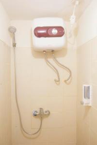baño con ducha y dispensador de jabón en la pared en DE GREEN INN Kebon Jeruk, en Yakarta