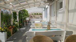 a row of white tables and chairs on a patio at Tramontana Family & Wellness in Darlowko