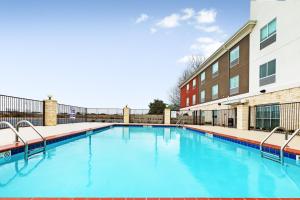 una piscina con acqua blu di fronte a un edificio di Holiday Inn Express & Suites Junction, an IHG Hotel a Junction City