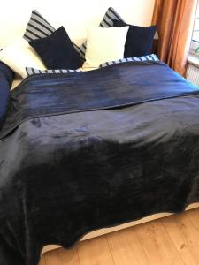 a black comforter on a bed in a room at Ferienwohnung CASA ELLEN in Glücksburg