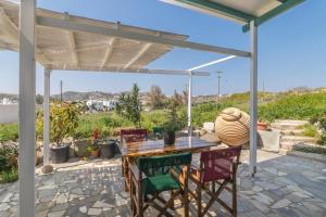 un patio con mesa de madera y sillas en wood and stone en Adamas