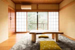 uma sala de estar com um banco e uma grande janela em Oyado Yaokyu 1st Floor in 4 Story Building - Vacation STAY 6713 em Ome