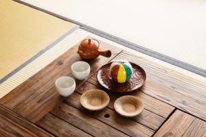 uma mesa com tigelas, um bule e um bolo em Oyado Yaokyu 1st Floor in 4 Story Building - Vacation STAY 6713 em Ome