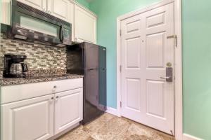a kitchen with a white door and a microwave at South Walton Condos II in Inlet Beach