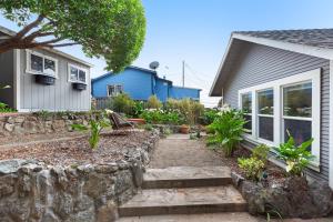 a garden with a stone wall next to a house at Surfer's Paradise in Bodega Bay