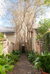 a brick walkway leading to a house with trees at Audubon Cottages in New Orleans