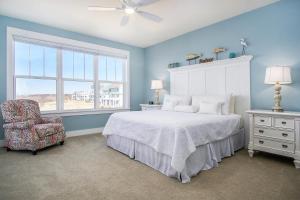 a bedroom with a bed and a chair and a window at Blue Haven in South Haven