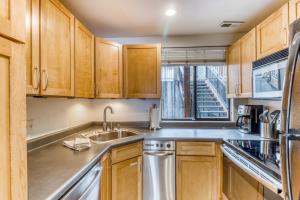 une cuisine avec des armoires en bois et un évier dans l'établissement Woodside Condo #3, à Park City