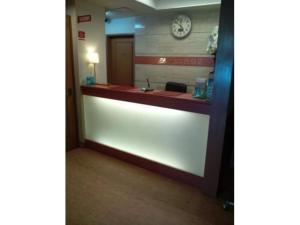 a reception desk in a hospital room with a clock on the wall at City Inn Nishi Tanabe / Vacation STAY 78536 in Osaka